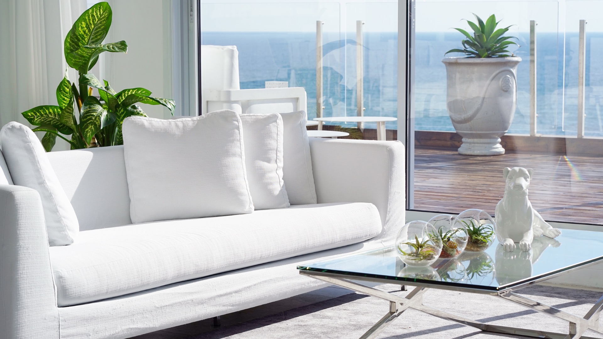 Salon contemporain blanc ouvert sur une terrasse avec vue mer